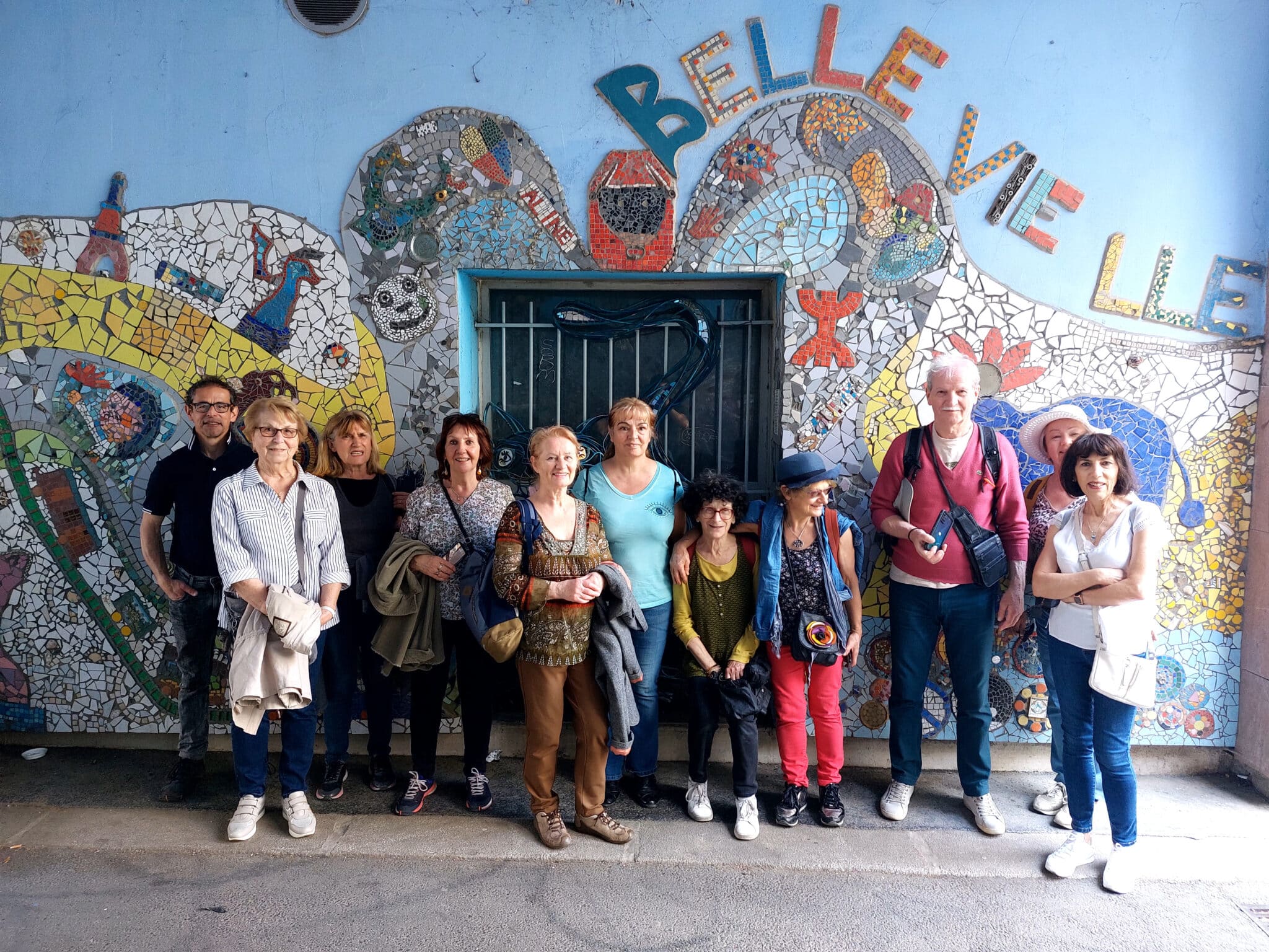 Groupe de visiteurs devant une oeuvre de street art à Belleville, Paris