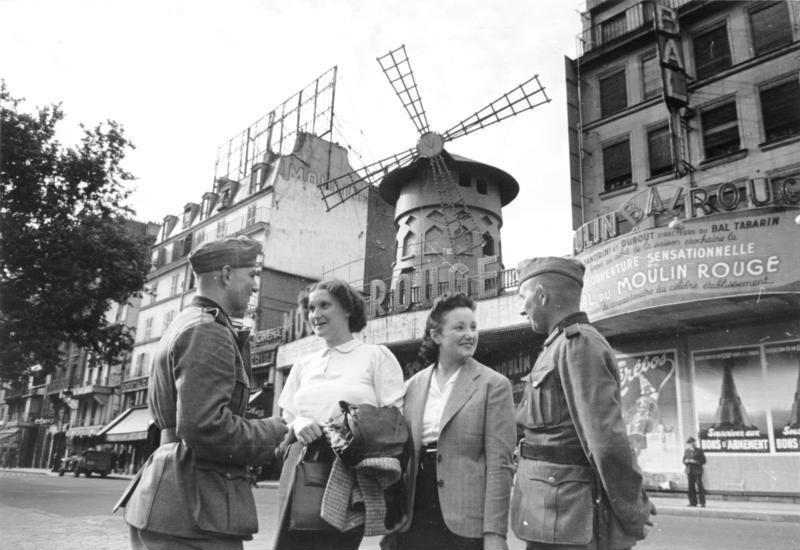 Des soldats allemands devant le Moulin-Rouge, en juin 1940, pendant l’occupation allemande de Paris lors de la Seconde Guerre mondiale